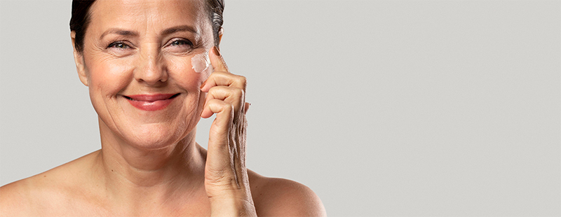 Femme souriante appliquant de la crème